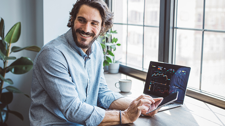 man smiling in front of a laptop