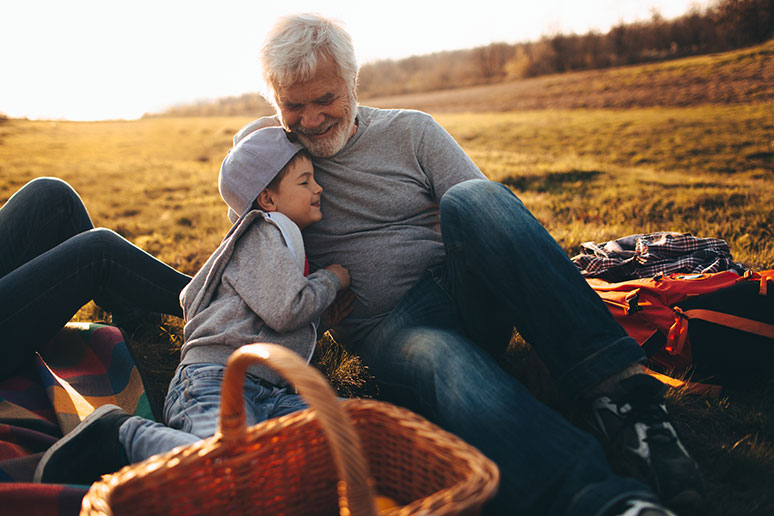Elderly man and grandson enjoying a picnic